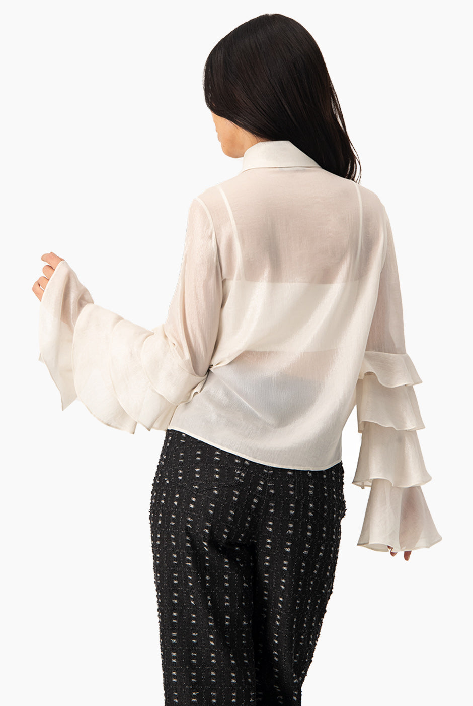 Blusa natural de manga larga con olanes y botones frontales.