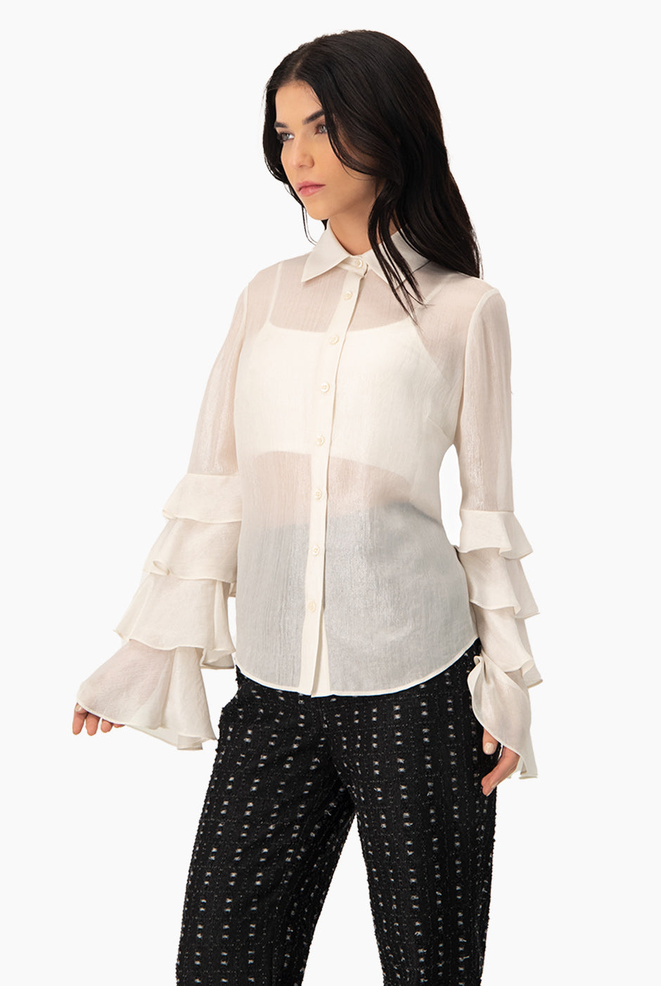 Blusa natural de manga larga con olanes y botones frontales.