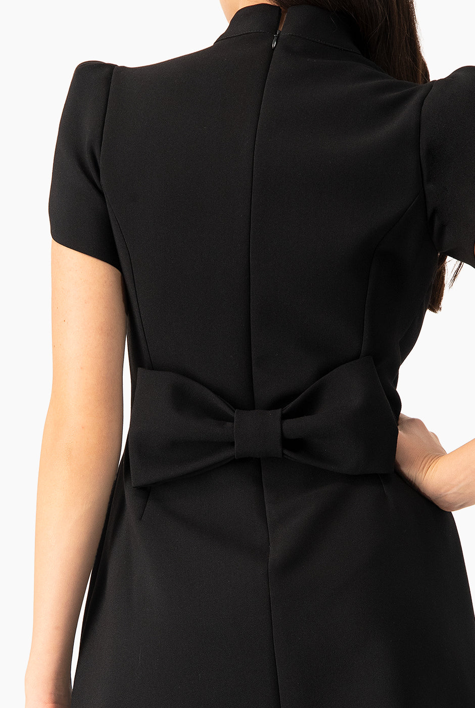 Vestido corto negro con moño trasero y hombreras estructuradas