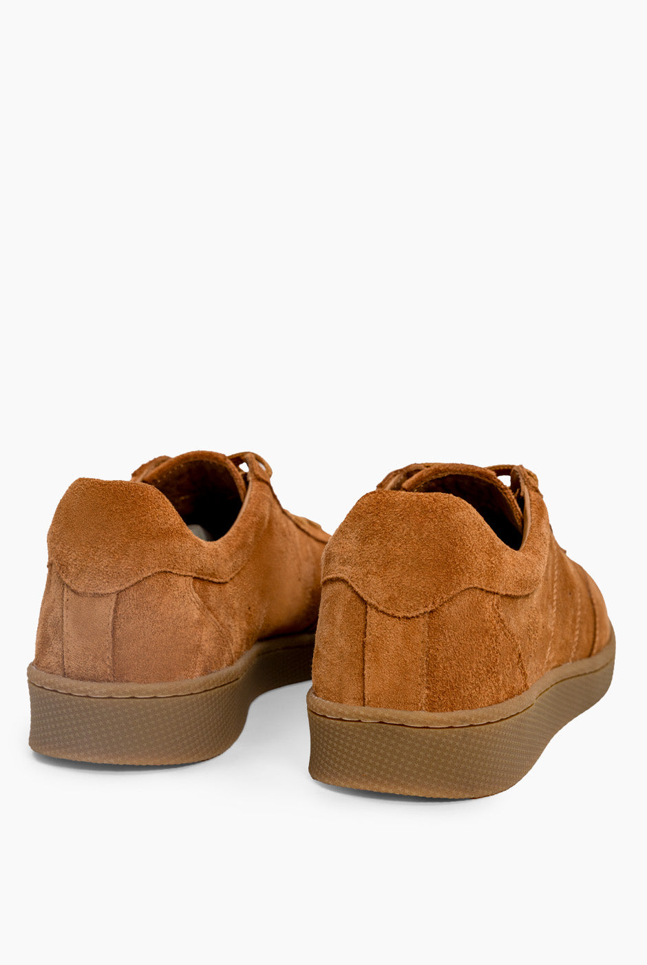 Tenis marrones de gamuza con cordones y costuras visibles.